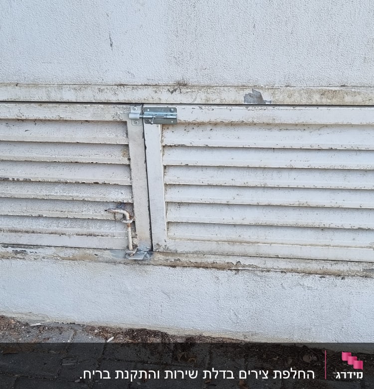 מסגרת מתכת עם תריסים על קיר בטון